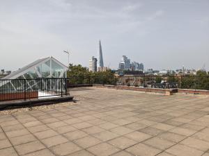 a building with a glass roof with a city in the background at Flat in Elephant and Castle in London