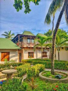 a house with palm trees in front of it at Hotel Rosario de Mar by Tequendama in Isla Grande