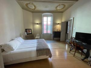 a bedroom with a bed and a desk and a piano at BB A PARMA DUOMO in Parma