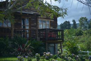 a log cabin with a balcony in a garden at LA PERLA FINCA HOTEL-Cabaña Amatista in Gigante
