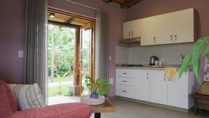 a kitchen with white cabinets and a red couch at LA PERLA FINCA HOTEL-Cabaña Amatista in Gigante