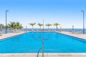 a large blue swimming pool with the ocean in the background at Keys to Happiness in Marathon