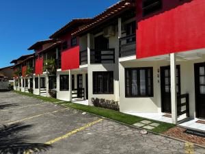 una fila de edificios con pintura roja y blanca en Apart perto da praia, en Porto Seguro
