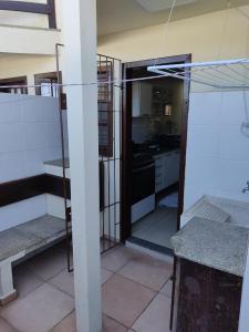 Vistas a una cocina con puerta a una habitación en Apart perto da praia, en Porto Seguro