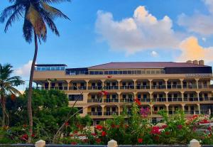 a hotel with a palm tree and a building at Myah's Hotel in Brighton Village
