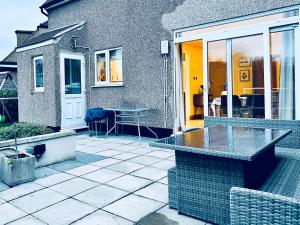 Cette maison dispose d'une terrasse avec une table. dans l'établissement Zoya’s Place in Harrow, à Pinner