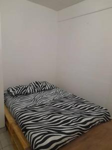 uma cama preta e branca num quarto em Cœur De Ville em Fort-de-France