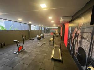 a gym with several exercise bikes and a painting on the wall at Daho Hotel in Natal