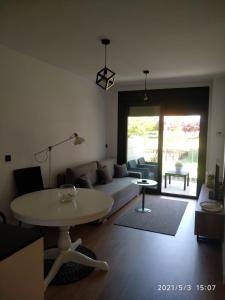 ein Wohnzimmer mit einem Sofa und einem Tisch in der Unterkunft Apartamento en Edificio Nuevo con Piscina in Portonovo