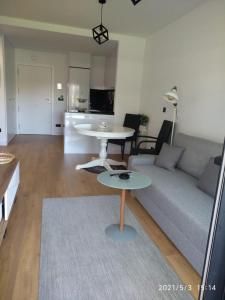 ein Wohnzimmer mit einem Sofa und einem Tisch in der Unterkunft Apartamento en Edificio Nuevo con Piscina in Portonovo
