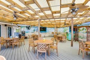 un patio con mesas y sillas y un mural en HH Beach & Tennis 132C, en Hilton Head Island