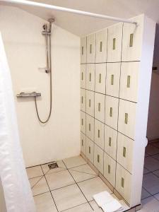 a bathroom with a shower and a tiled floor at Perlos Apartamentai 14 in Birštonas
