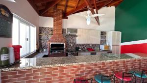 a kitchen with red and green walls and a counter with stools at Chácara Familiar Boituva in Boituva