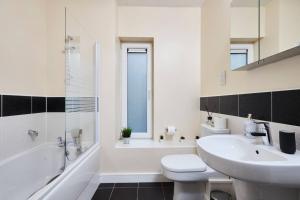 a white bathroom with a sink and a tub and a toilet at Exquisite City Centre house - Parking & Garden in Sheffield