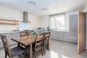 a kitchen with a wooden table and some chairs at Exquisite City Centre house - Parking & Garden in Sheffield