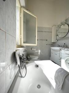 ein weißes Bad mit einem Waschbecken und einem WC in der Unterkunft Viareggio ampia casa con giardino in Viareggio