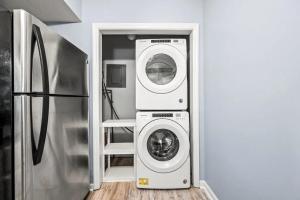 a laundry room with a washer and dryer next to a refrigerator at VIEWS and FIREPLACE and Minutes to Gburg and Ober in Gatlinburg