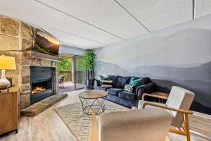 a living room with a couch and a fireplace at VIEWS & POOL - Minutes to Gburg and Ober - Condo in Gatlinburg