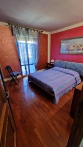 a bedroom with a large bed and a red wall at La casa di Luca in Abbadia San Salvatore +12 photos