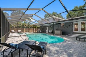 a patio with a swimming pool with a table and chairs at Clearwater 2 story pool home mins from the beach in Clearwater