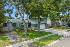 una casa azul con árboles en el patio en Clearwater 2 story pool home mins from the beach, en Clearwater