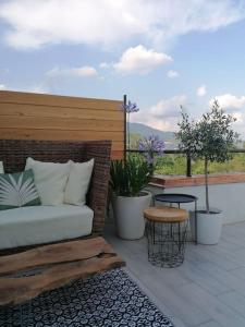 patio z kanapą, doniczkami i stołem w obiekcie Panoramic Apartment Grace21 w mieście Bregano