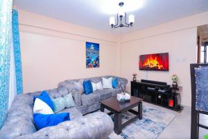 One bedroom furnished apartment ,south B في نيروبي: غرفة معيشة مع أريكة ومدفأة