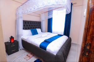 One bedroom furnished apartment ,south B في نيروبي: غرفة نوم مع سرير مظلة ونافذة