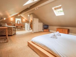 een slaapkamer met een groot bed en een woonkamer bij Dove Tail Barn in Underbarrow