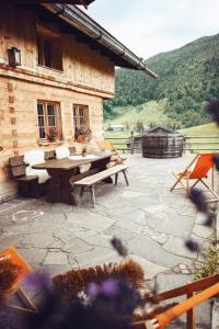 a stone patio with a picnic table and a building at Hasenalm in Schliersee