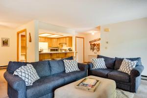 a living room with two couches and a table at Riverfront Lincoln Condo with Pool Mins to Loon Mtn in Lincoln
