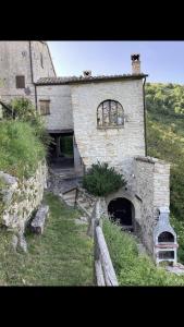 una vecchia casa in pietra con una recinzione di fronte di Al Castello di Elcito a San Severino Marche