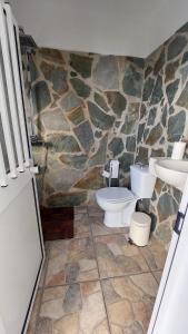 een badkamer met 2 toiletten en een stenen muur bij Villa Rubia in Málaga