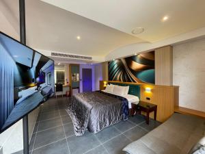 pokój hotelowy z łóżkiem i telewizorem z płaskim ekranem w obiekcie King & Princess Motel - Rende w mieście Rende