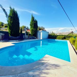 a swimming pool with blue water in a yard at Charming Villa Nika with the pool in Supetar
