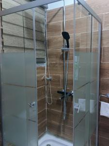 a shower with a glass door in a bathroom at LAKESIDe VILLA in Accra
