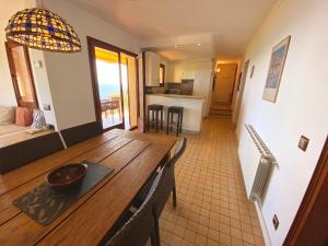 a living room with a wooden table and a kitchen at Spectacular Mediterranean view! in Palafrugell