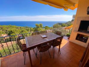 una mesa y sillas en un balcón con vistas al océano en Spectacular Mediterranean view!, en Palafrugell