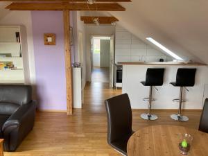 a living room with a table and chairs and a kitchen at Ferienwohnung Jeßberger in Bad Königshofen im Grabfeld +4 photos