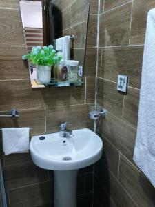 uma casa de banho com um lavatório e um espelho em LAKESIDe VILLA em Acra
