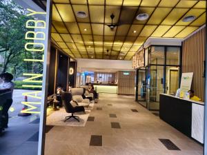 a lobby with people sitting in chairs in a building at Luxurious Ceylonz Suite near Bukit Bintang 4pax in Kuala Lumpur