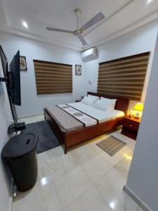 um quarto com uma cama e uma televisão em LAKESIDe VILLA em Acra
