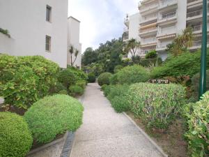a path in a garden with bushes and a building at Grand 3P à Menton avec terrasses et parkings - FR-1-196-331 in Menton