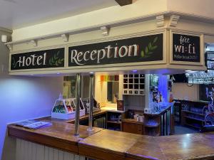 una señal de recepción del hotel sobre un mostrador en un restaurante en Feildens Arms & Hotel, en Balderstone