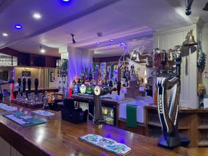 un bar con un montón de botellas de cerveza en Feildens Arms & Hotel, en Balderstone