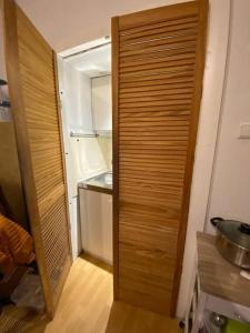 a wooden door in a kitchen with a refrigerator at Middle of the city center, with balcony in Hannover