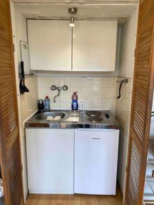 a small kitchen with white cabinets and a sink at Middle of the city center, with balcony in Hannover