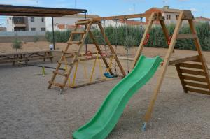 un parque infantil con un tobogán verde y una escalera en Casa Rural Finca Bella, en San Clemente