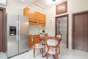 eine Küche mit einem Tisch und Stühlen sowie einem Kühlschrank in der Unterkunft Διαμέρισμα με αυλή στη Μέλισσα in Xánthi