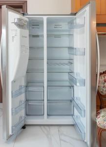 una nevera blanca con puertas abiertas en una cocina en Διαμέρισμα με αυλή στη Μέλισσα en Xanthi